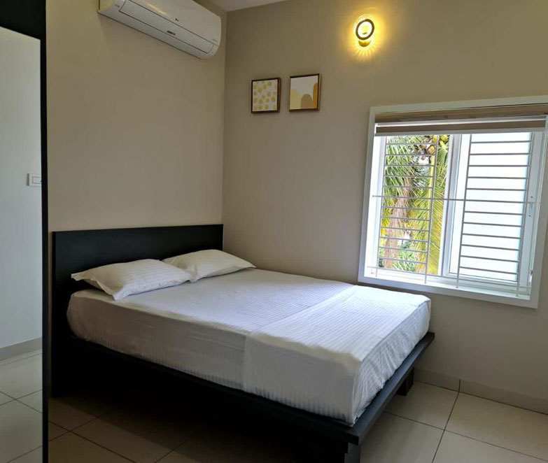 Large, airy bedroom in Pollachi homestay with natural lighting